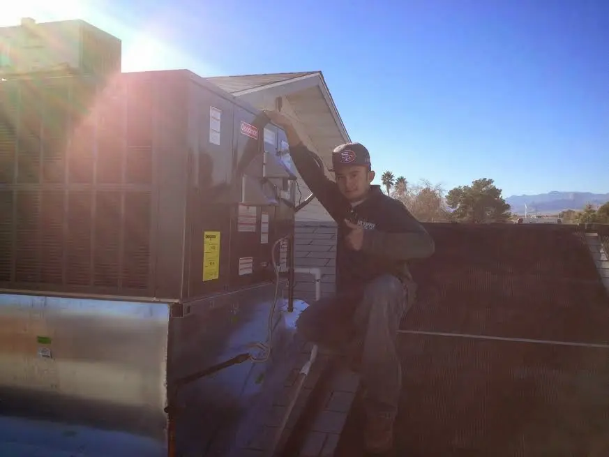 HVAC technician performing AC Tune-Up on a rooftop unit in Mount Vista